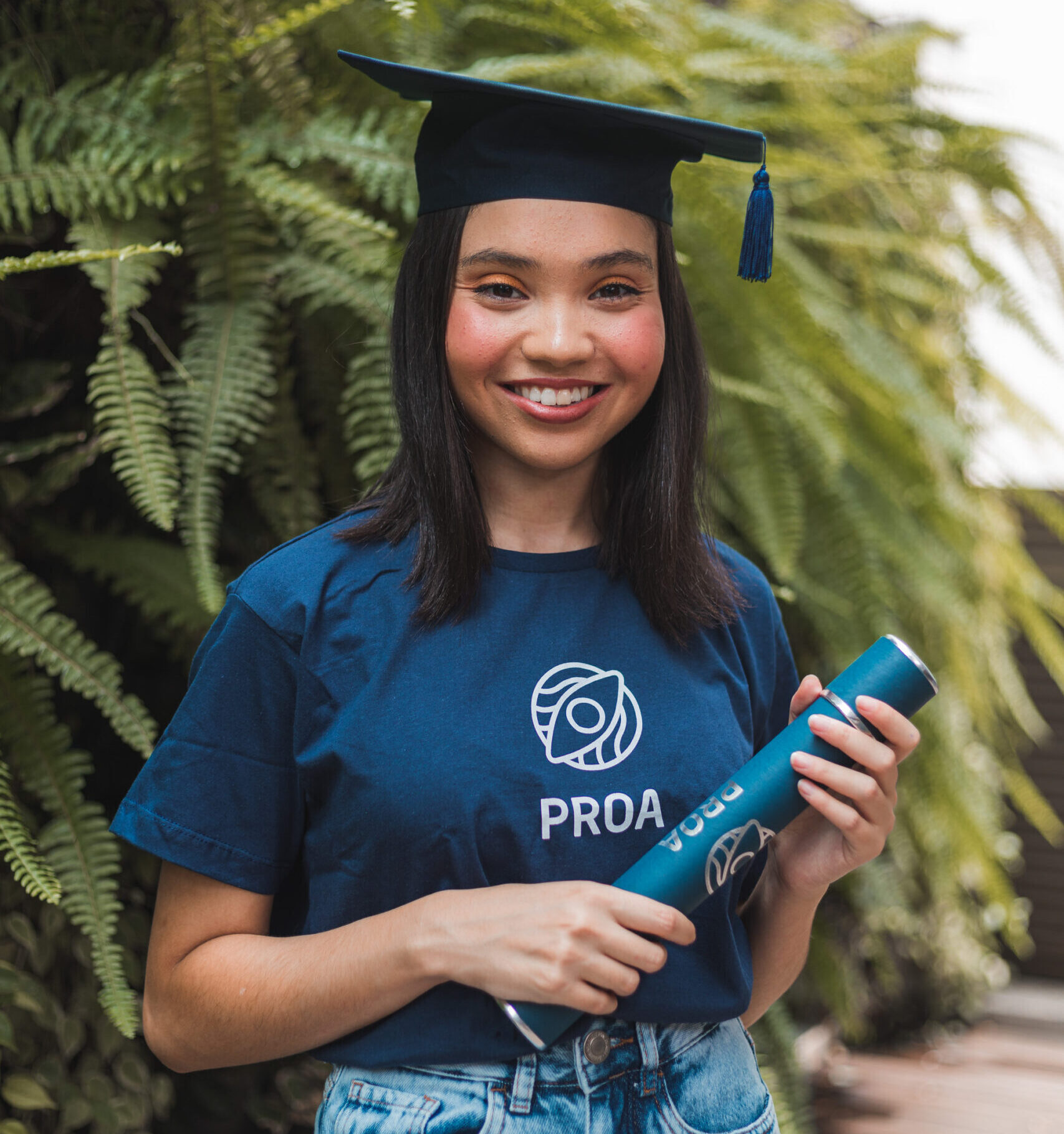 Aluna do projeto social proa segurando o diploma
