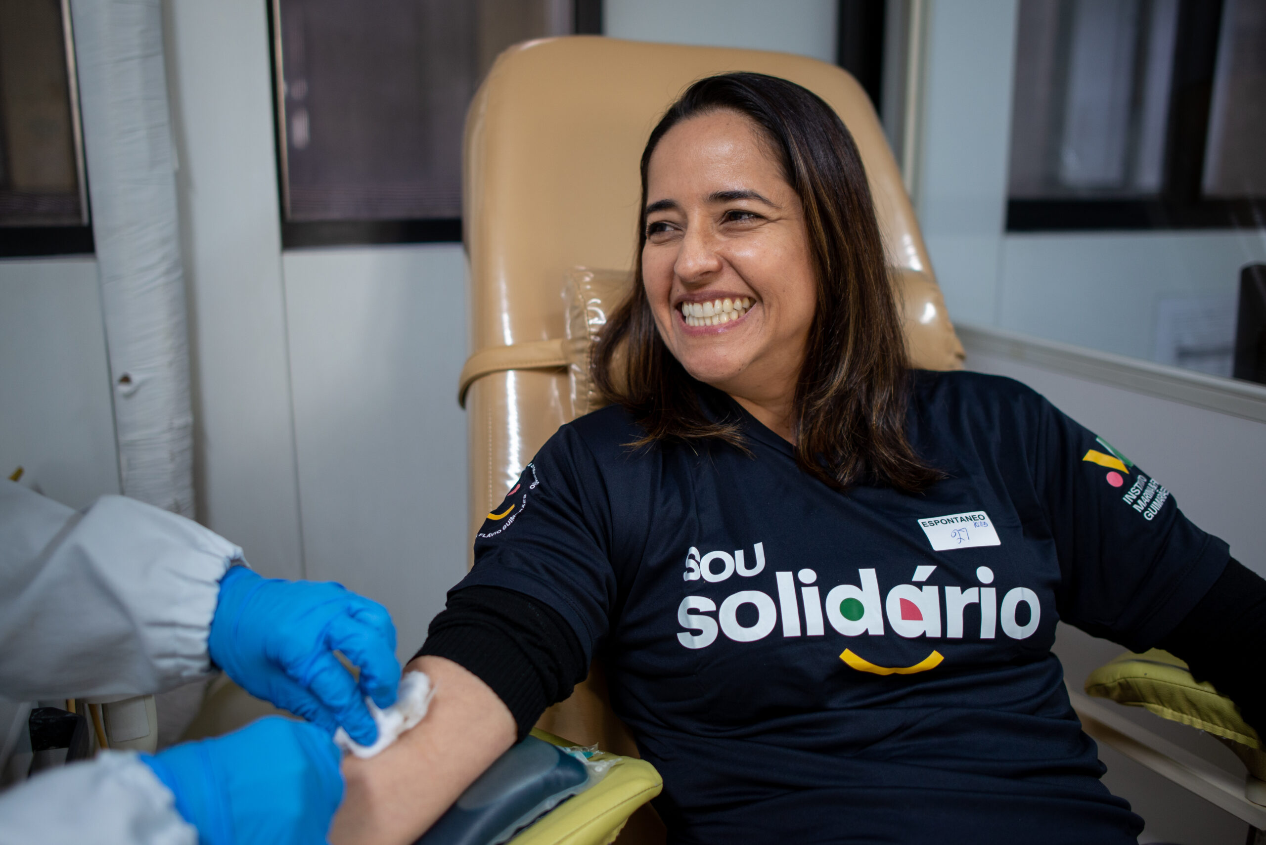 Voluntária do Bmg doando sangue em uma ação do projeto social MF solidário