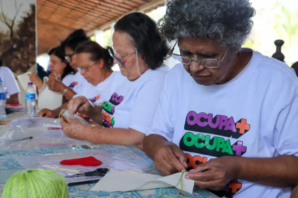 Alunas atentas do projeto social Ocupa+ fazendo artesanato
