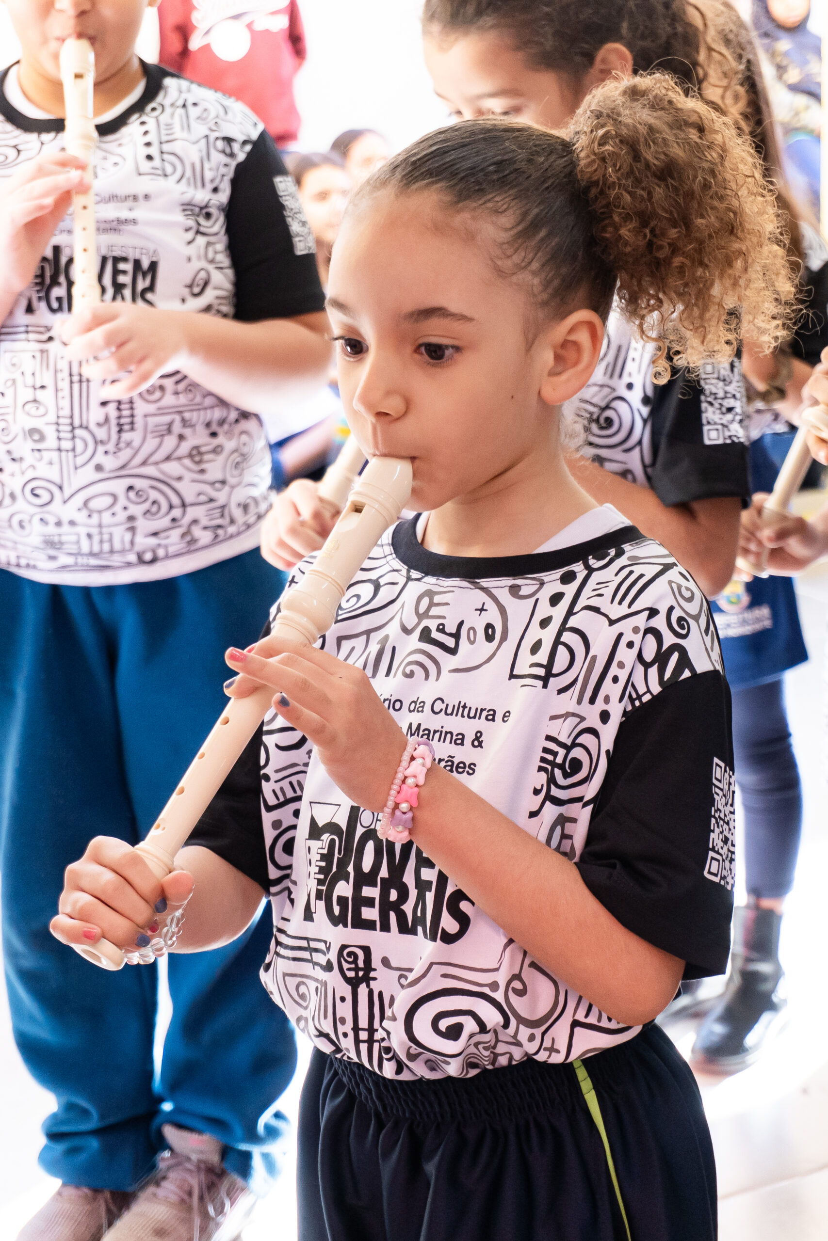 Criança aluna do projeto social Orquestra Jovem das Gerais tocando flauta